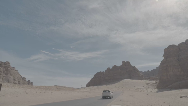 سيارة على طريق صحراوي في العلا، لقطة نهارية.