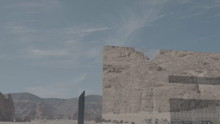 مبنى بواجهة زجاجية يعكس الجبال في العلا، لقطة نهارية.