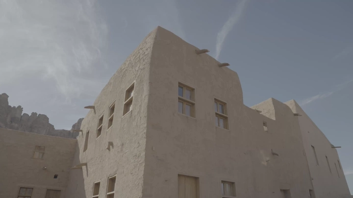 مبنى تقليدي في العلا تحت السماء الزرقاء، لقطة بزاوية منخفضة.