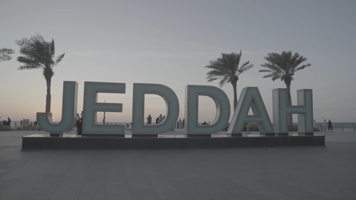 حروف جدة على الكورنيش عند الغروب، لقطة واسعة.