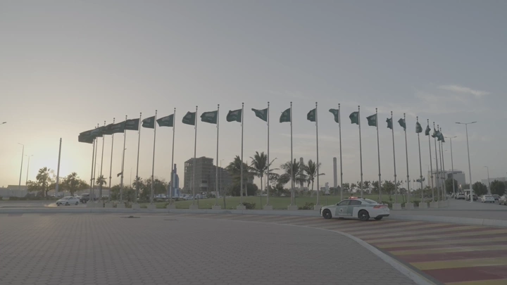 مجموعة أعلام سعودية في جدة عند الغروب، لقطة أرضية.