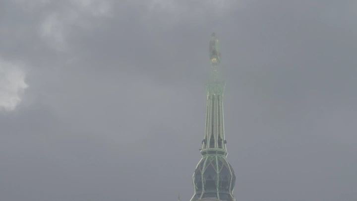 قمة برج الساعة في مكة تحت السماء الغائمة، لقطة عن قرب.