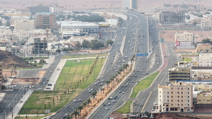 طريق سريع في حائل مع مباني محيطة، لقطة جوية.