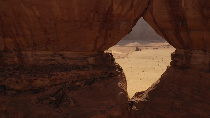 تكوين صخري في العلا يظهر من خلاله الصحراء، تصوير درون.