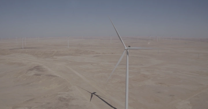 توربينات رياح في صحراء تحت سماء زرقاء، تصوير درون.