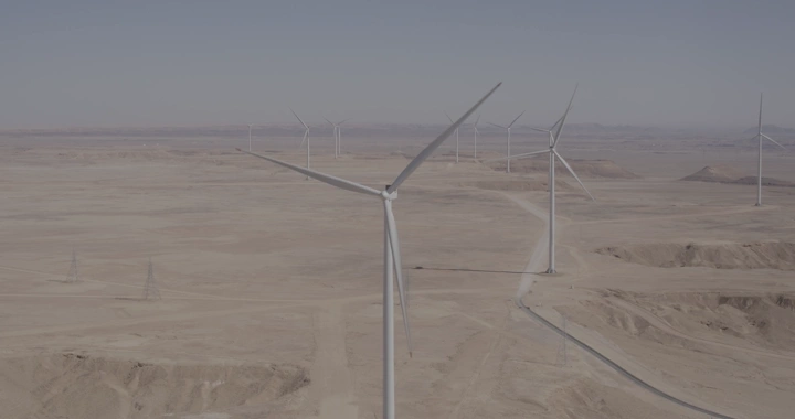 توربينات رياح في صحراء تحت سماء صافية، تصوير درون.