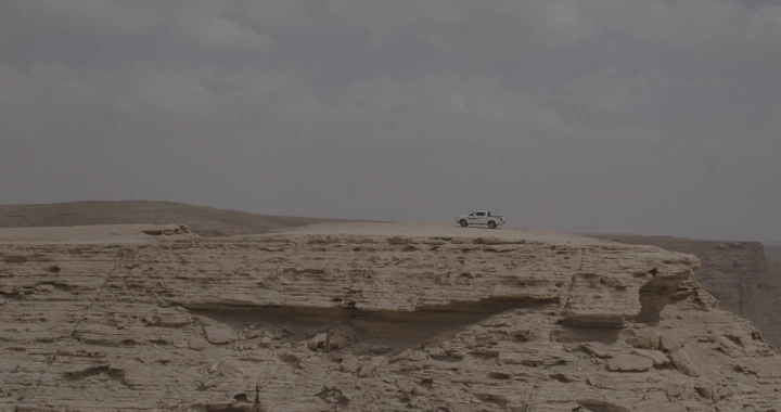 سيارة على حافة جرف صخري في الرياض، لقطة بعيدة.