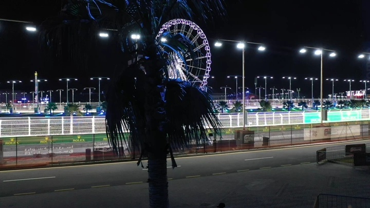 حلبة كورنيش جدة ليلاً مع عجلة فيريس مضاءة، لقطة ليلية.