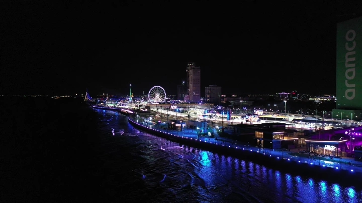 حلبة كورنيش جدة ليلاً بإضاءة ملونة، لقطة جوية.