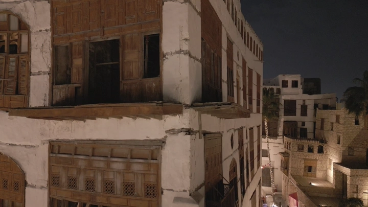 مباني تاريخية في جدة القديمة ليلاً، لقطة بزاوية واسعة.