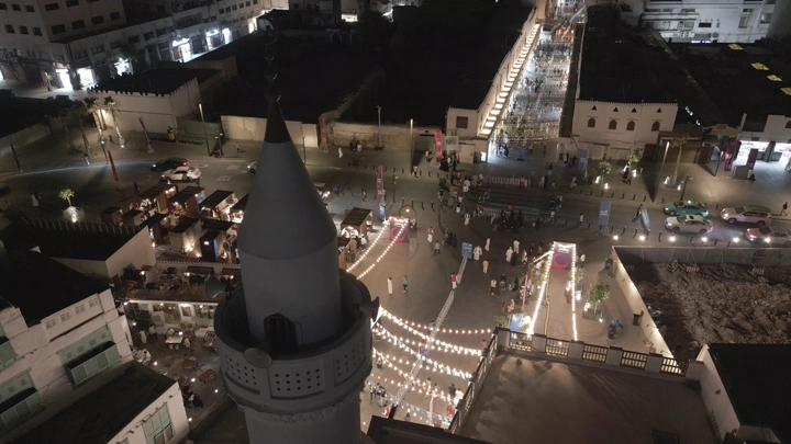 منظر جوي لجدة القديمة ليلاً مع أضواء وزحام الناس.