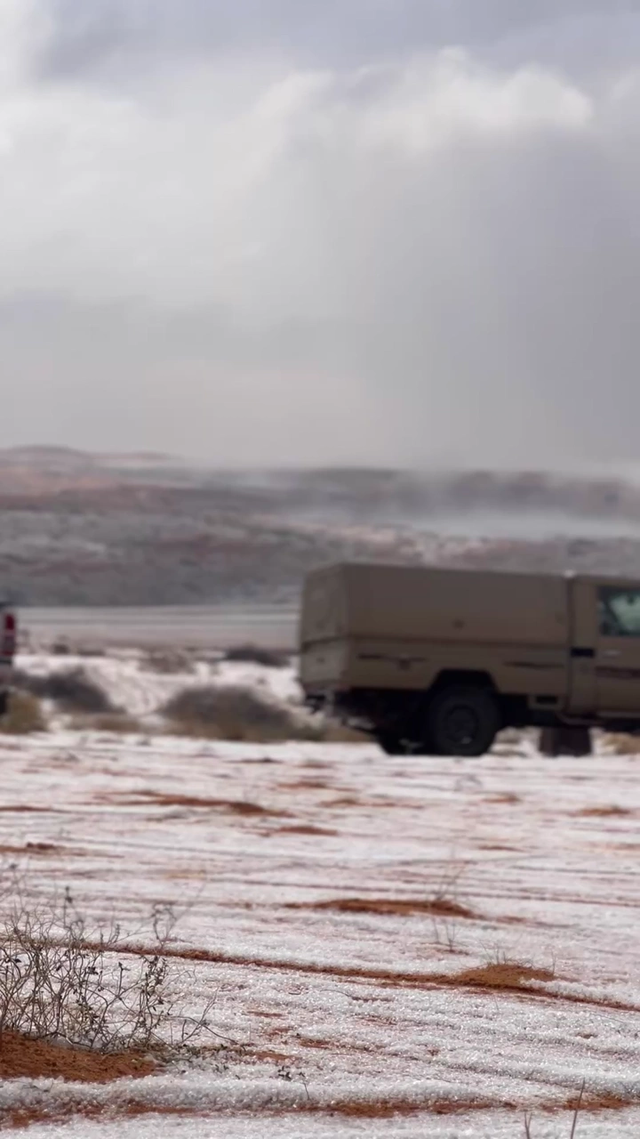 سيارة في صحراء النفود مغطاة بالبرد، لقطة نهارية.