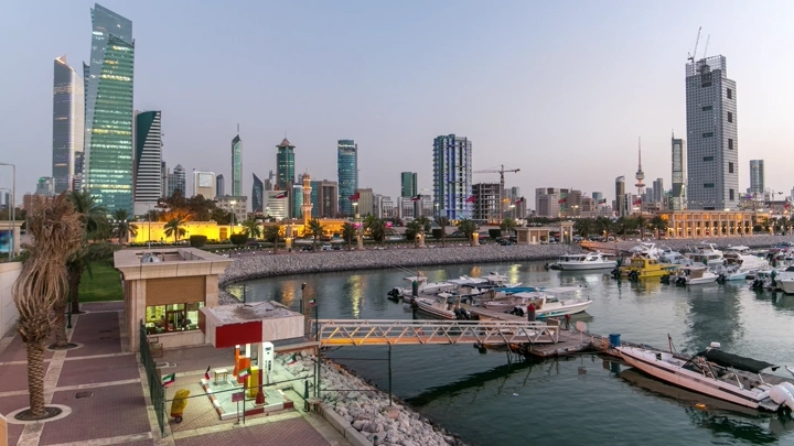 ناطحات سحاب مضاءة في مدينة الكويت ليلاً مع المرسى، تصوير تايم لابس.