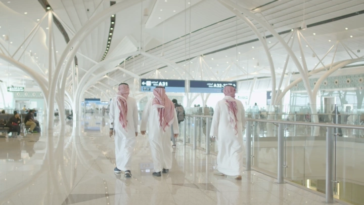 مسافرون في صالة مطار حديثة بجدة، لقطة واسعة.
