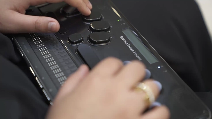 شخص يستخدم جهاز برايل إلكتروني، لقطة مقربة.