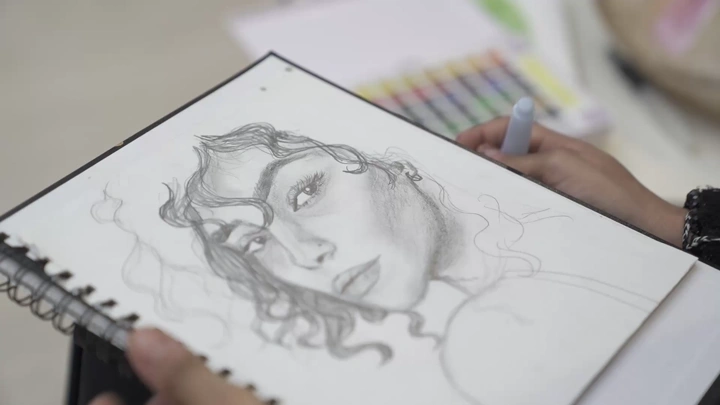 رسم يدوي لوجه امرأة، لقطة مقربة، أدوات رسم ملونة بالخلفية.