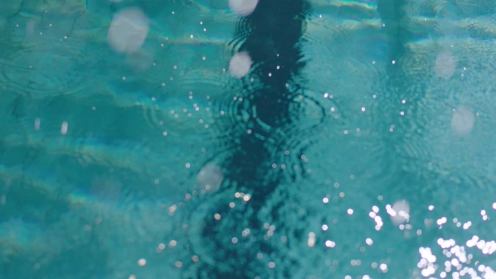 A close-up slow-motion shot of a professional swimmer swimming in the pool.