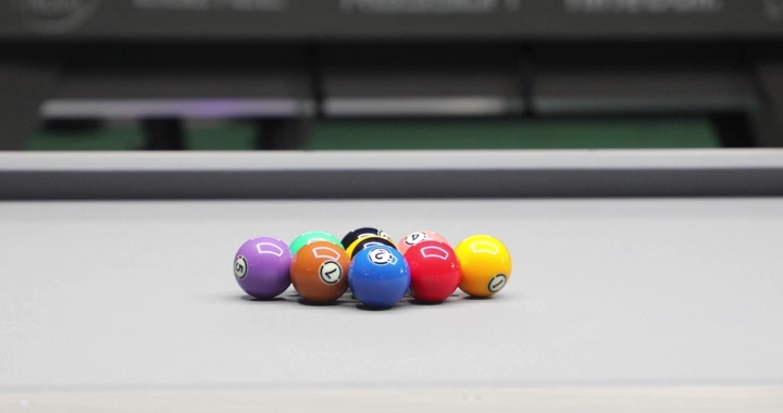 Colored billiard balls will be hit on a billiard table, close-up shot.