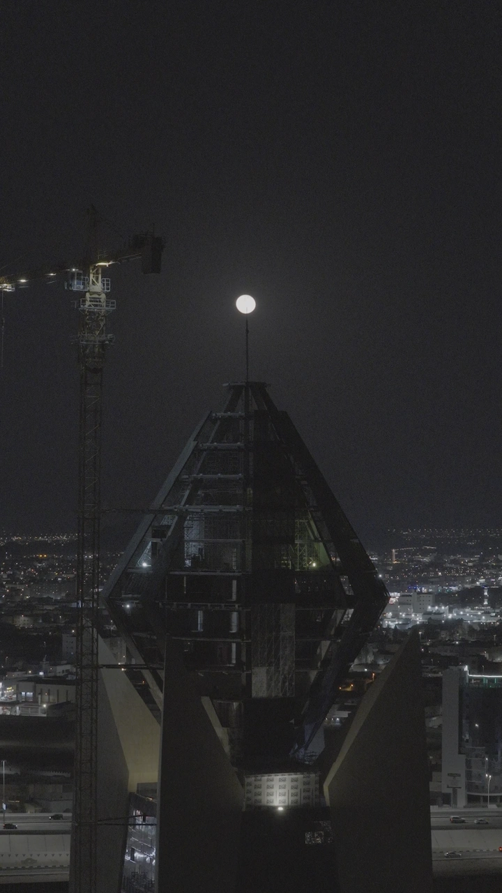 برج الجوهرة في حائل ليلاً مع القمر في الخلفية، لقطة ليلية.