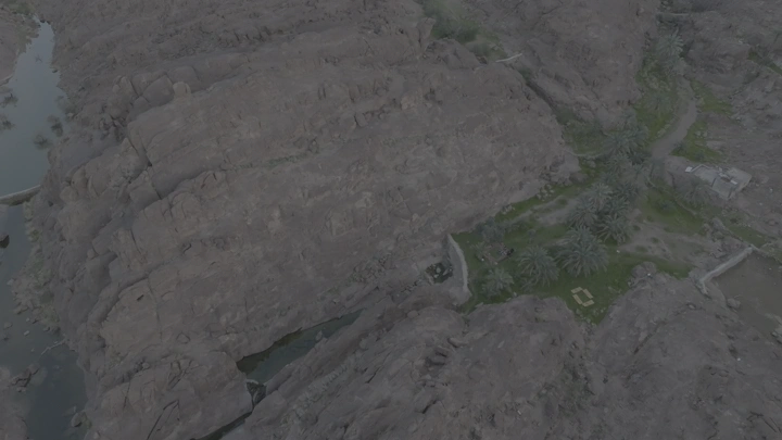 منظر جوي للجبال بعد الأمطار مع واحة صغيرة.