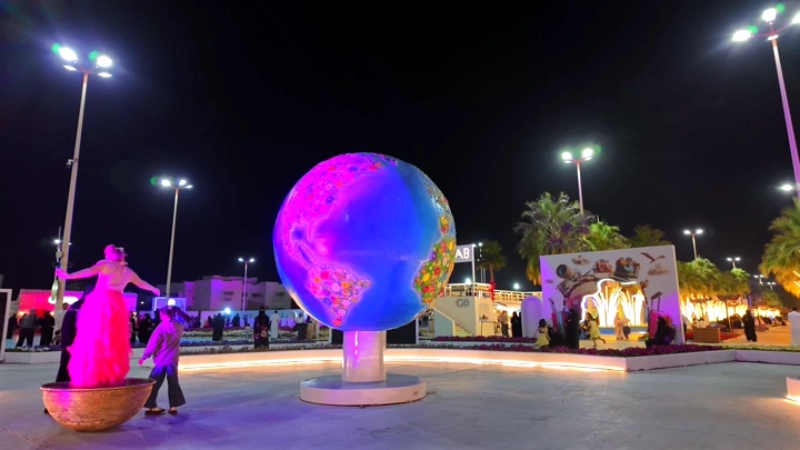 Illuminated globe sculpture at Yanbu Flower and Garden Festival, night shot.