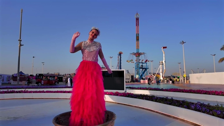 Woman in pink dress at flower festival in Yanbu Industrial, daytime shot.