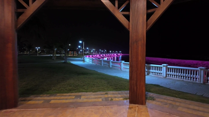 A river illuminated in pink in Yanbu, a night shot.
