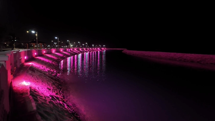 Pink lighting on the beach at night in Yanbu, a nighttime shot.