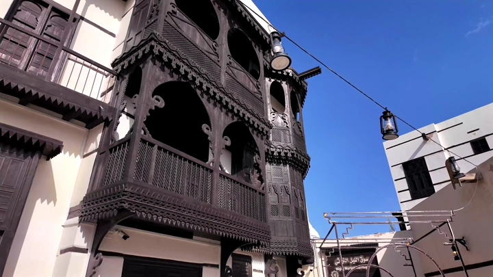 Old houses in a historic neighborhood in Yanbu under a blue sky, shot from below.