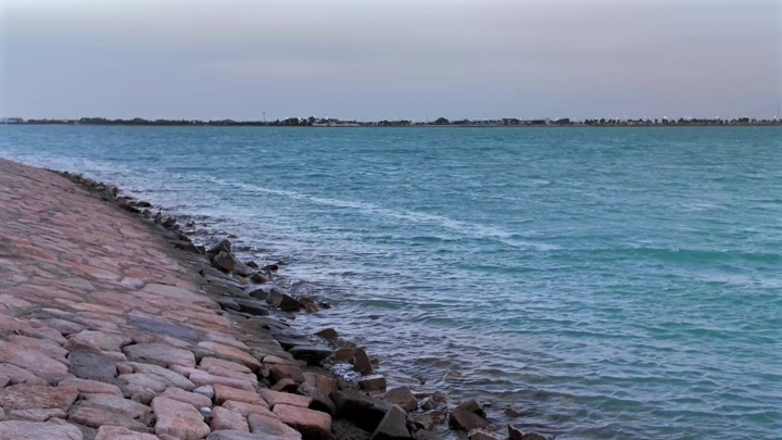 شاطئ صخري في ينبع مع مياه زرقاء، لقطة نهارية.