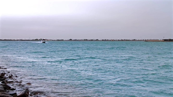 Boat in blue waters at Yanbu, shoreline shot.