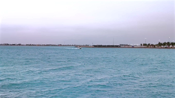 قارب صغير في البحر قرب الشاطئ، لقطة نهارية.