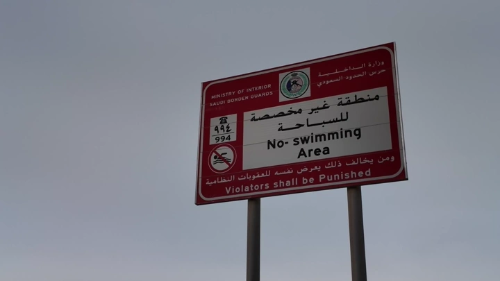 لافتة تحذيرية بعدم السباحة في منطقة معينة، لقطة نهارية.