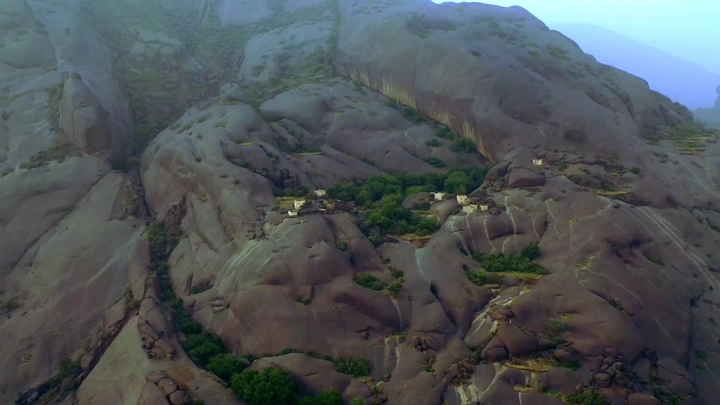 Ghey village in Asir region nestled among mountains, aerial shot.