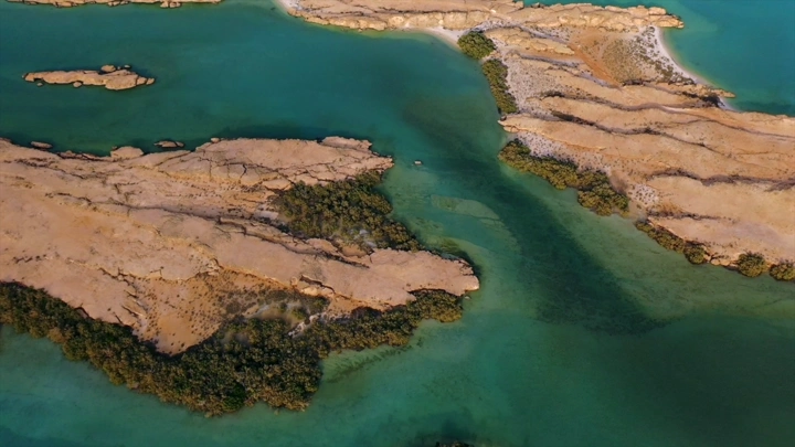 Aerial shot of the beaches of Farasan Island with blue waters and rocks, drone shot.
