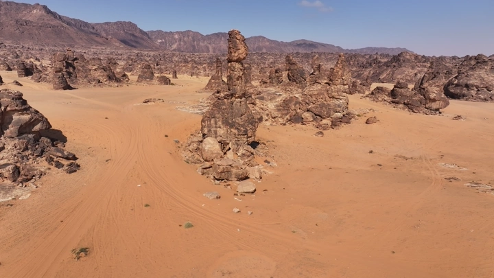 تكوينات صخرية في صحراء المسمى تحت سماء صافية، لقطة جوية.