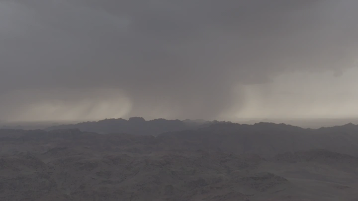 هطول الأمطار على قمم الجبال في حائل وقت غروب الشمس، لقطة بانورامية.