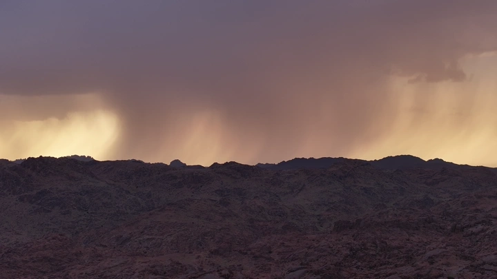 هطول الأمطار على قمم الجبال في حائل وقت غروب الشمس، منظر طبيعي.