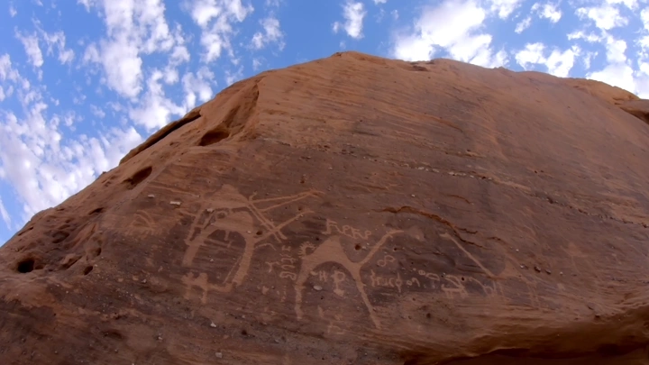 نقوش صخرية ثمودية في العلا تحت سماء زرقاء، لقطة منخفضة تايم لابس.