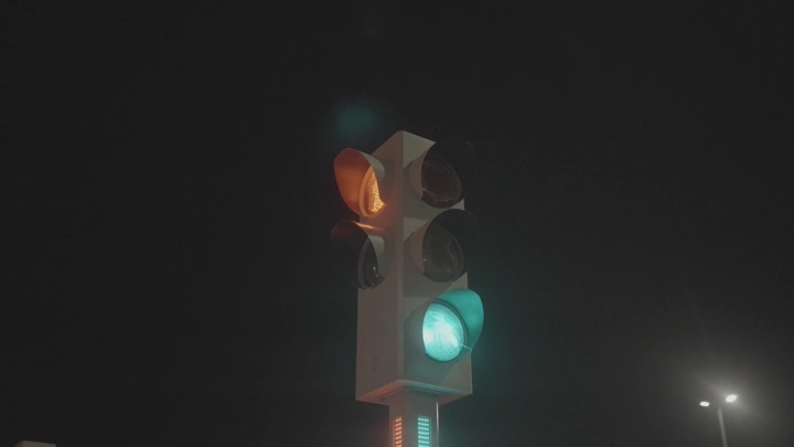 إشارة مرور مضاءة في الليل، لقطة قريبة.