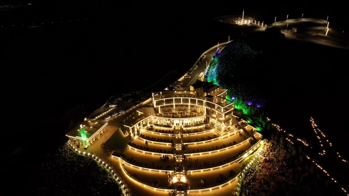 إطلالة جبل السمراء مضاءة ليلاً في حائل، لقطة جوية.