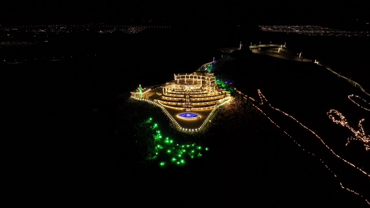 إطلالة جبل السمراء مضاءة ليلاً في حائل، لقطة جوية.