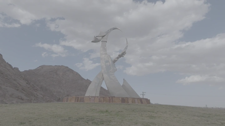 تمثال في حديقة حائل العامة تحت سماء غائمة، لقطة نهارية.