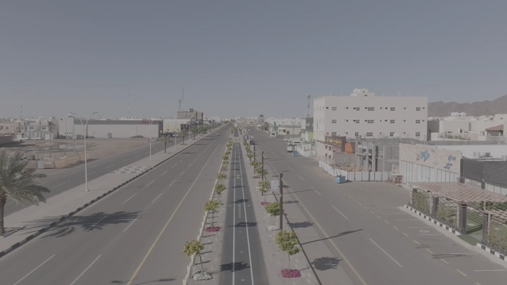 شارع طويل مع ممشى وحديقة في حائل، لقطة جوية.