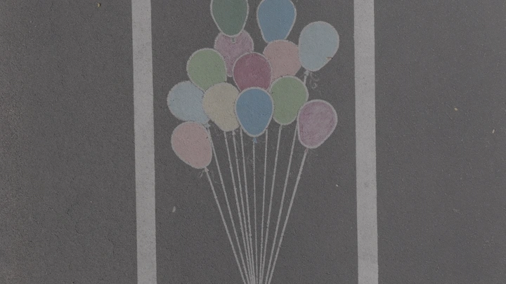 بالونات ملونة مرسومة على ممشى في حائل، لقطة جوية اسقاطية.