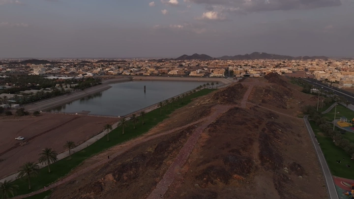 منظر جوي لحديقة الورود يتوسطها بحيرة في حائل، عند الغروب.