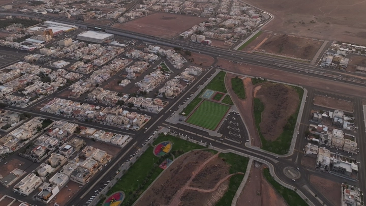 مشهد جوي لحديقة عامة وملعب كرة قدم في حائل.