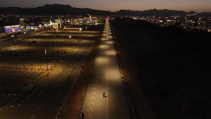 طريق مضاء في حديقة حائل العامة ليلاً، لقطة جوية.