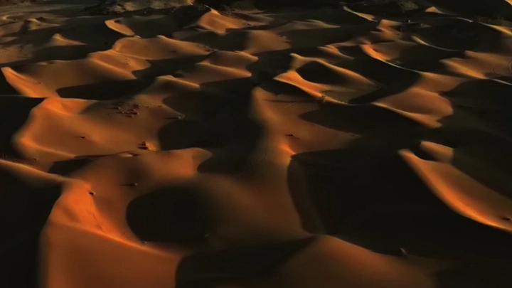 كثبان رملية في الصحراء عند الغروب، منظر جوي.