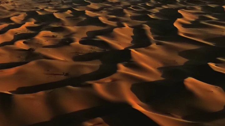 كثبان رملية في الصحراء عند الغروب، لقطة جوية.